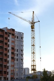 Construction site with tower crane near unfinished building