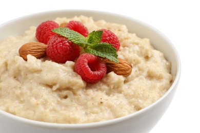 Tasty oatmeal porridge with raspberries and almond nuts in bowl on white background, closeup