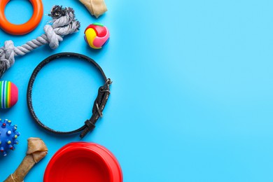 Flat lay composition with dog collar and different accessories on light blue background, space for text