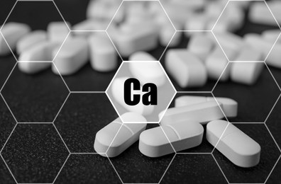 Calcium supplement pills on black background, closeup