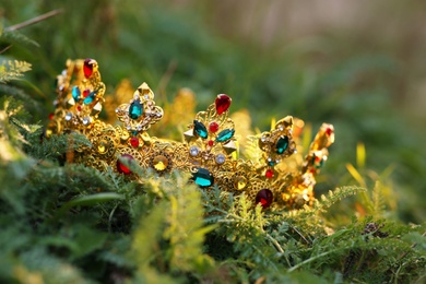 Beautiful golden crown on fresh green grass, closeup. Fantasy item