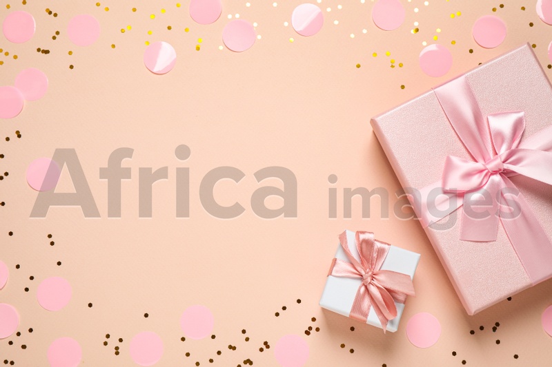 Frame of shiny confetti and beautiful gift boxes on color background, flat lay. Space for text