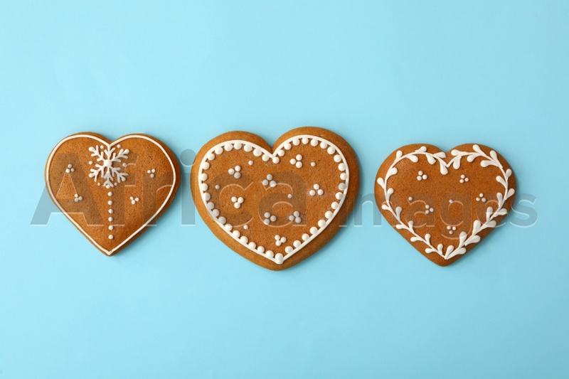 Christmas heart shaped gingerbread cookies on light blue background, flat lay