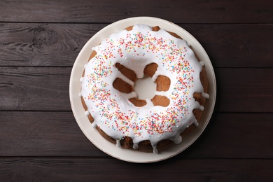Glazed Easter cake with sprinkles on wooden table, top view