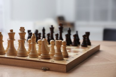 Chess board with pieces on wooden table