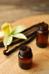 Aromatic homemade vanilla extract on wooden table, closeup