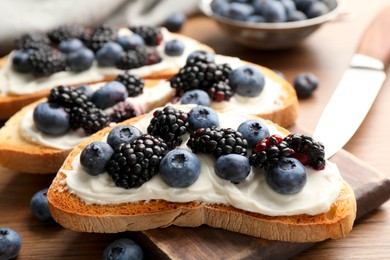 Tasty sandwiches with cream cheese and berries, closeup