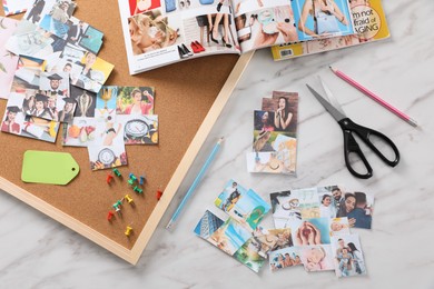 Flat lay composition with different photos, magazines and stationery on white marble background. Creating vision board