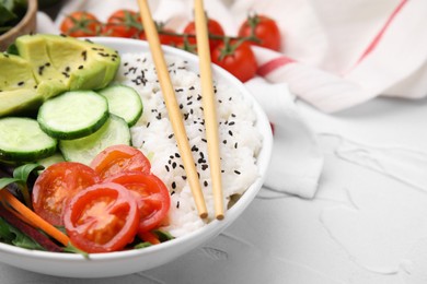 Photo of Delicious poke bowl with vegetables, avocado and mesclun on white table, closeup