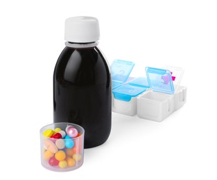 Bottle of syrup, measuring cup with pills on white background. Cough and cold medicine