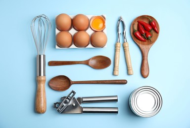 Cooking utensils and ingredients on light blue background, flat lay