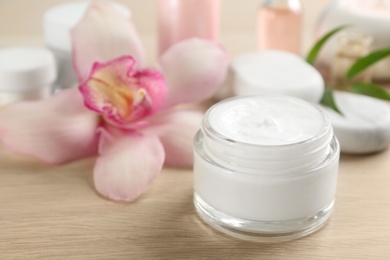 Beautiful spa composition with cosmetic product and flower on table, closeup