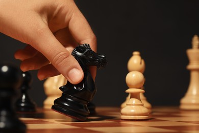 Woman moving chess piece on board, closeup