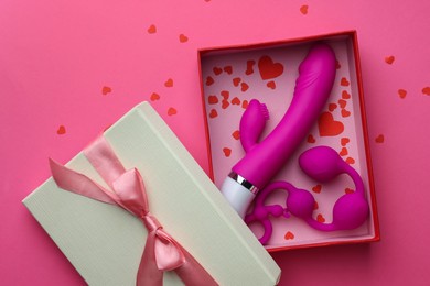 Gift box with sex toys on pink background, top view