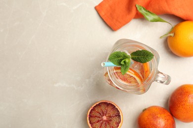 Delicious refreshing drink with sicilian orange and mint on grey table, flat lay. Space for text