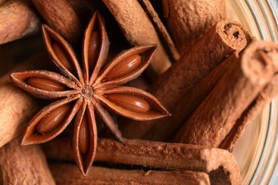 Aromatic cinnamon sticks and anise star in bowl, top view