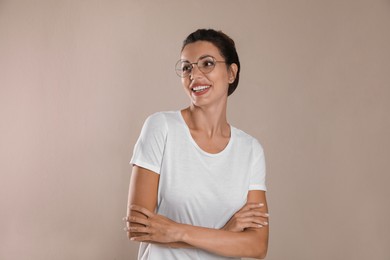 Beautiful woman in eyeglasses on light brown background