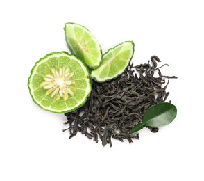 Pile of dry bergamot tea leaves and fresh fruit on white background, top view