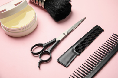 Professional hairstyling tools on light pink background