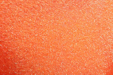 Shiny bright glitter on coral background, flat lay