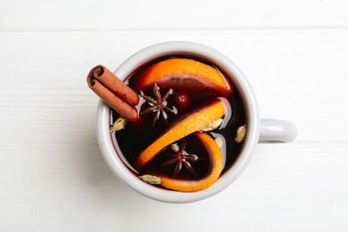 Aromatic mulled wine on white wooden table, top view