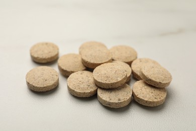 Dietary supplement pills on white table, closeup