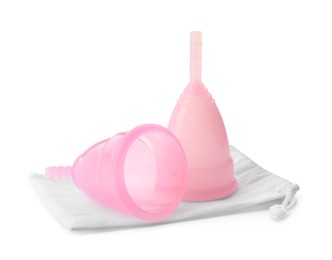 Pink menstrual cups with cotton bag on white background