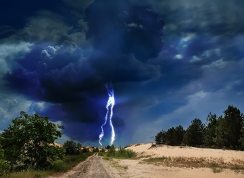 Picturesque thunderstorm in desert. Lightning striking from dark cloudy sky