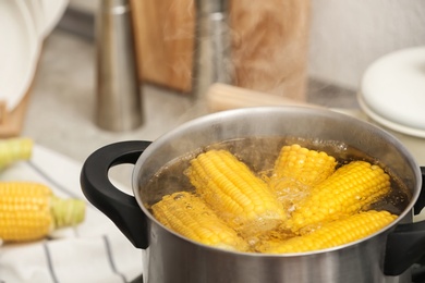 Stewpot with boiling water and corn cobs, closeup