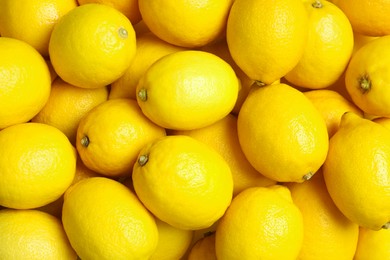 Many fresh ripe lemons as background, top view