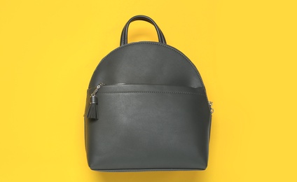 Stylish urban backpack on yellow background, top view