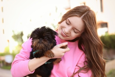 Young woman with adorable Brussels Griffon dog outdoors