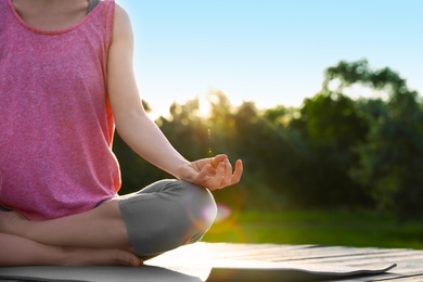 Young woman practicing yoga outdoors, closeup. Zen meditation