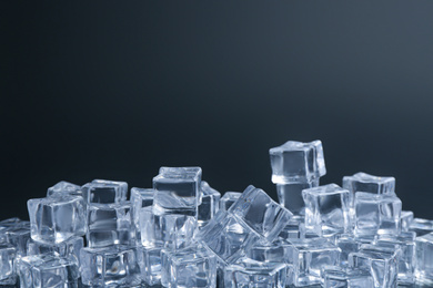 Crystal clear ice cubes on black background. Space for text