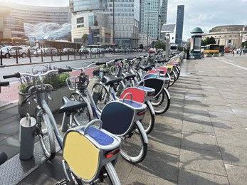 Many bicycles parked outdoors. Bike rental service
