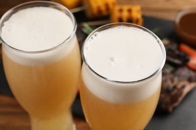 Photo of Glasses of tasty beer on table, closeup view