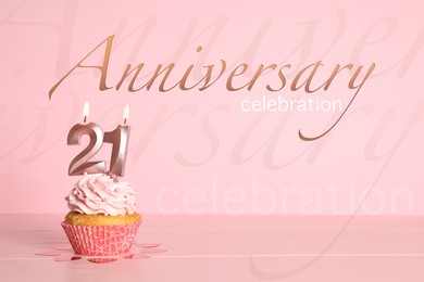 Delicious cupcake with number shaped candles on pink background. Coming of age party - 21th birthday. Anniversary celebration