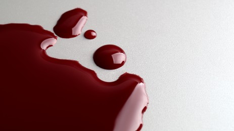 Stain and drops of blood on light grey background, closeup. Space for text