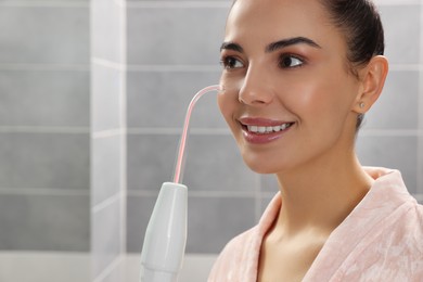 Photo of Woman using high frequency darsonval device in bathroom, closeup. Space for text
