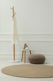 Simple hall interior with pouf, clothes rack and decor elements. Space for text