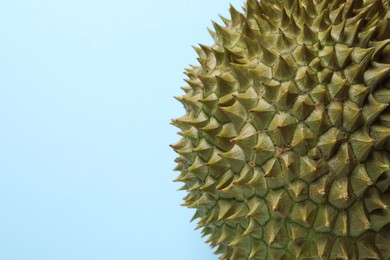 Photo of Fresh ripe durian on light blue background, closeup. Space for text