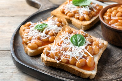 Toasts with delicious canned beans on wooden table, closeup