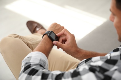 Man with smart watch on blurred background, closeup