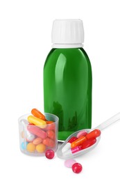 Photo of Bottle of syrup, measuring cup, plastic spoon with pills on white background. Cough and cold medicine