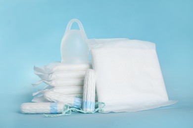Menstrual pads and other hygiene products on light blue background