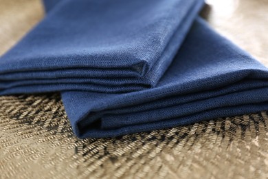 Blue kitchen napkins on textured background, closeup