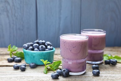 Photo of Freshly made blueberry smoothie on wooden table. Space for text
