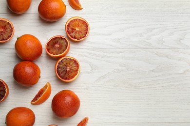 Many ripe sicilian oranges on white wooden table, flat lay. Space for text