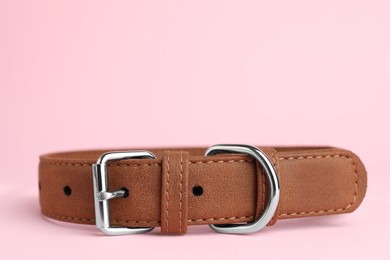 Brown leather dog collar on pink background, closeup. Space for text