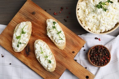 Photo of Bread with cottage cheese and microgreens on wooden table, flat lay
